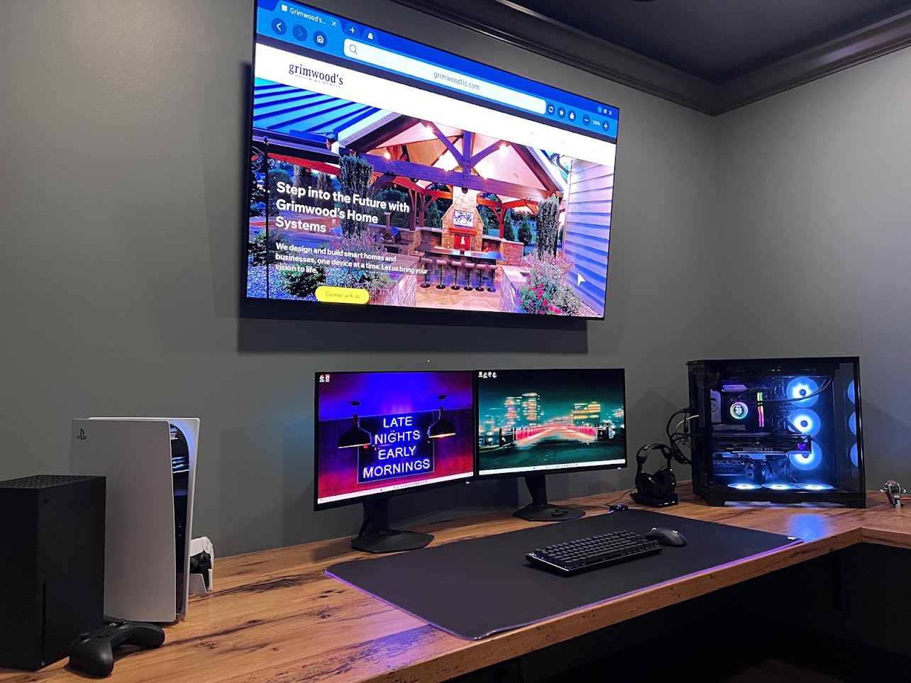 Lancaster home gaming room with a wall-mounted TV, dual monitors and gaming consoles.