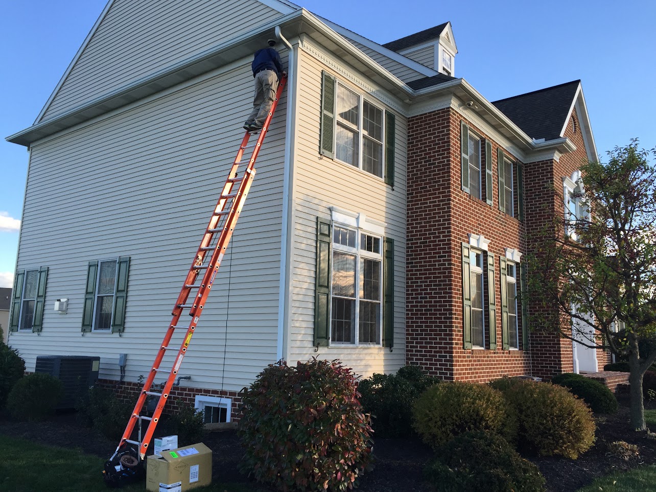 Alex working from a ladder at a brick-and-siding home in Shadow Creek, Lebanon, PA.