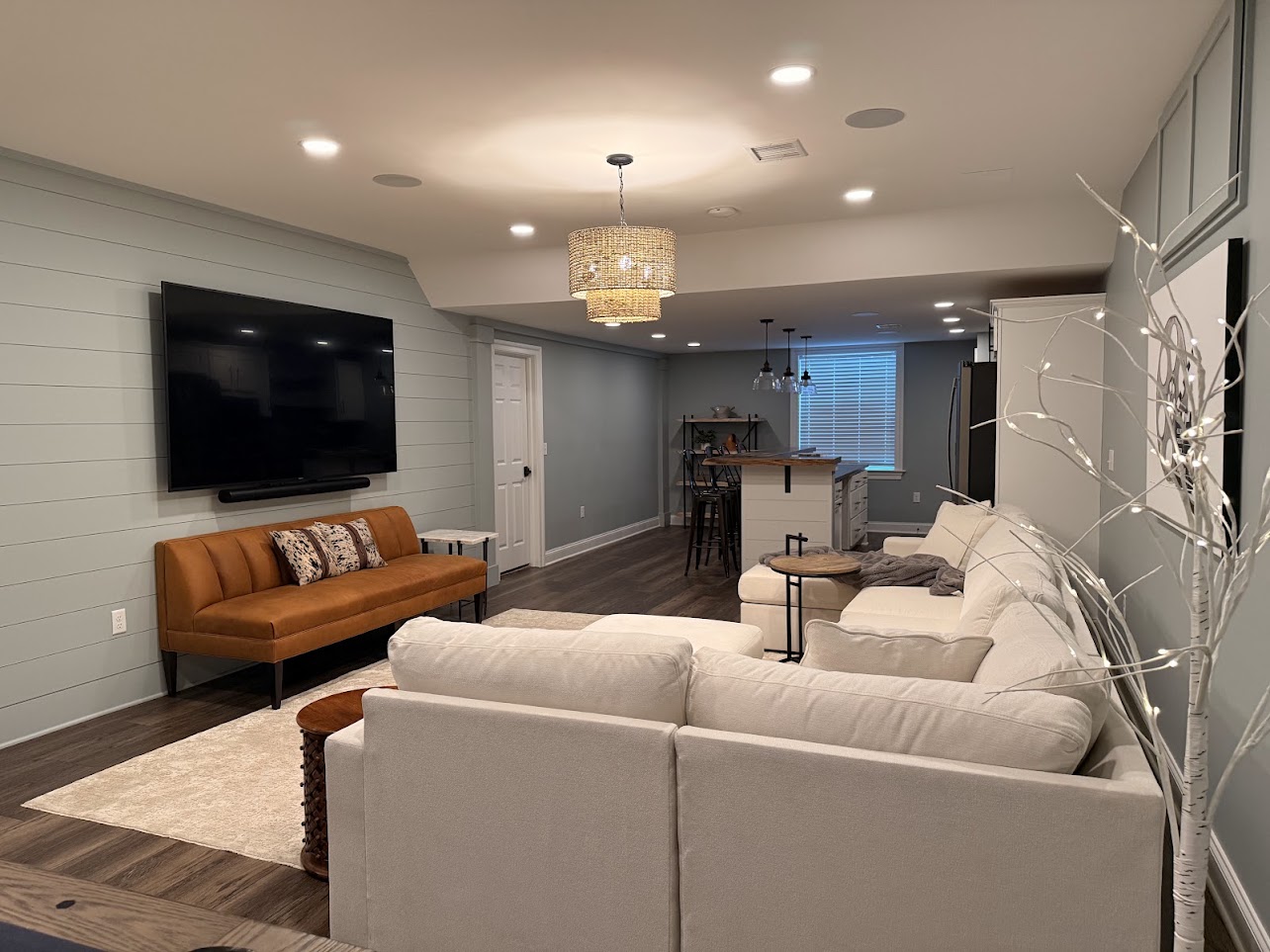 Renovated basement in Lancaster, PA, with a wall-mounted television and in-ceiling speakers.